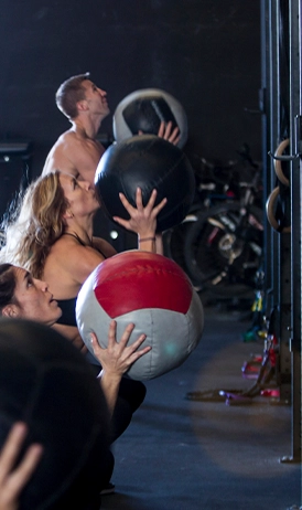 Groupe en plein entraînement fonctionnel au gym PN Fitness dans la Petite-Nation, lançant des ballons médicinaux.